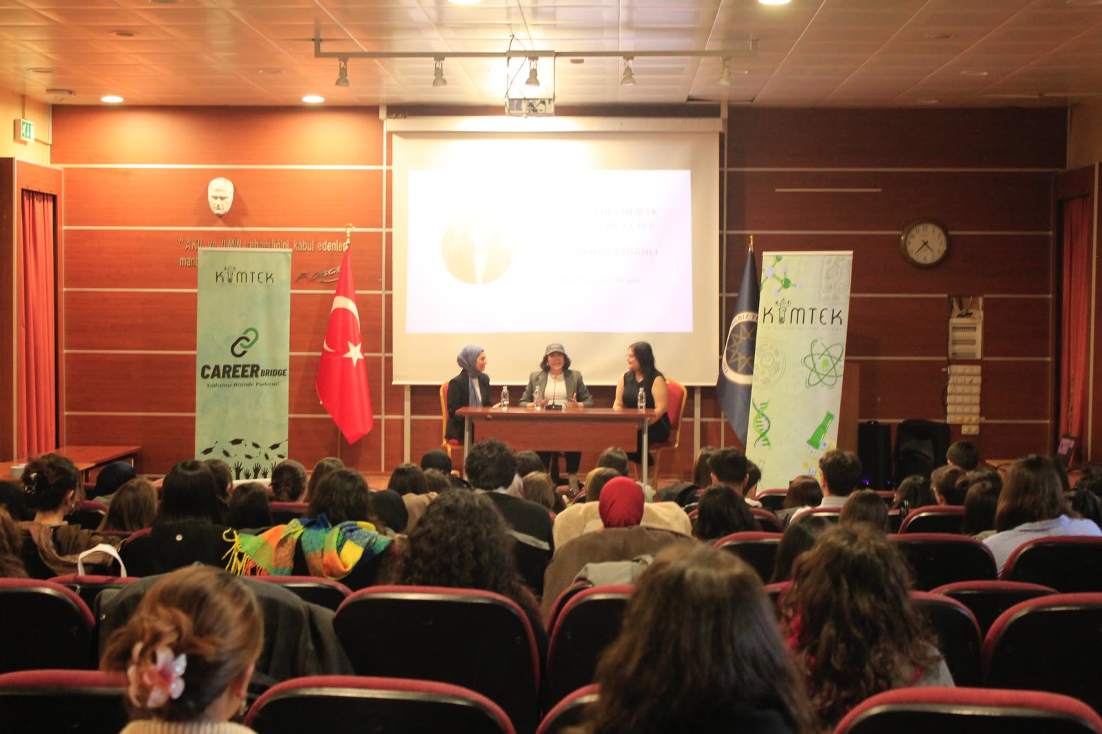 Career Bridge'in Sektörde Kadın Olmak TeaTalk etkinliğinde salonu dolduran öğrenciler ve sahnedeki konuşmacılar